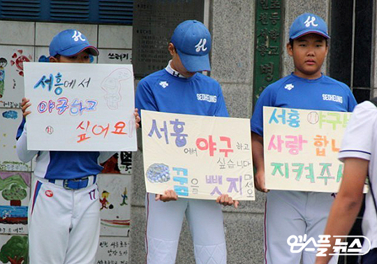 해체 위기를 맞은 서흥초 야구부 학생들이 피켓을 들고 시위하고 있다(사진=엠스플뉴스).
