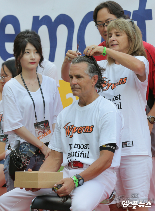 힐만 감독은 소아암 아동을 돕기 위해 1년 전부터 머리카락을 길렀다. 행사에 참여중인 힐만 감독과 그의 아내 마리 여사가 ‘힐만 팔찌’를 차고 있다. (사진=SK)