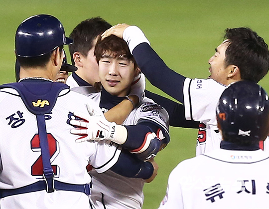 박건우가 한국시리즈 2차전 끝내기 안타 뒤 팀 동료들의 뜨거운 축하를 받고 있다(사진=엠스플뉴스 강명호 기자)