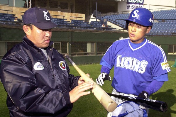 현역 심판 시절 국민타자 이승엽과 함께 배트를 살펴보는 오석환 심판위원장(사진=삼성)