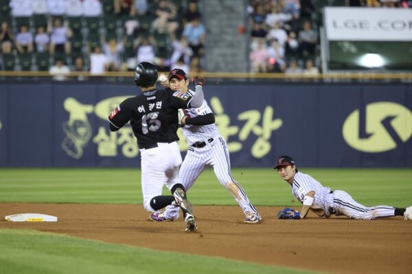 LG 신민재가 30일 잠실 KT전에서 6회 슬라이딩 캐치 후 공을 토스한 뒤 병살 플레이를 완성시키고 있는 오지환을 바라보고 있다. 사진 | LG