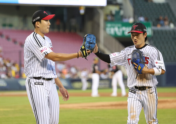 LG 신민재가 호수비 후 덕아웃으로 들어가며 손주영의 감사인사를 받고 있다. 사진 | LG