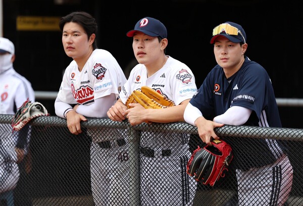 더그아웃에서 경기를 지켜보고 있는 두산 강현구(가운데). 사진 | 두산
