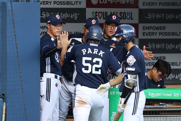 신인 박준순과 하이파이브를 하고 있는 조성환 감독대행. 사진 | 두산베어스