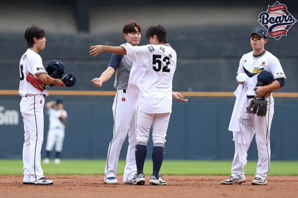 후배 박준순에게 유니폼을 벗어주는 김재호(사진=두산)